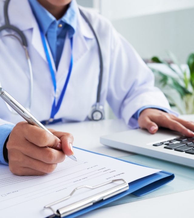 hands-unrecognizable-female-doctor-writing-form-typing-laptop-keyboard (2)